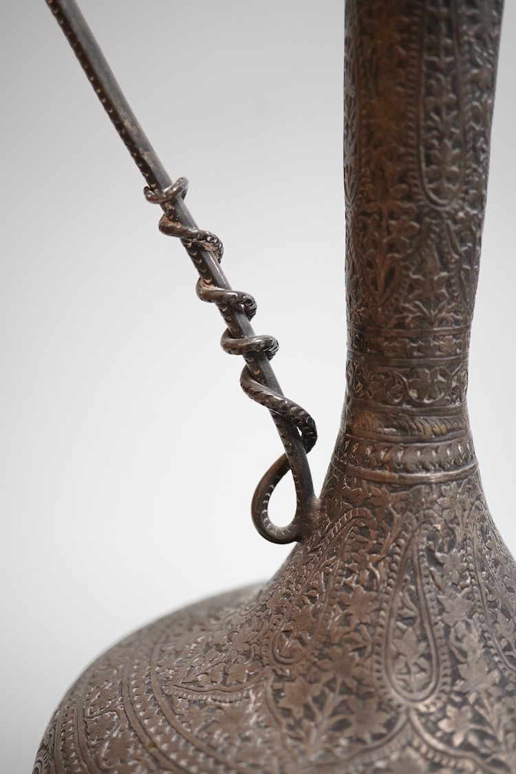 A late 19th century Indian white metal ewer, with extensive foliate decoration and cobra handle, height 30.3cm.